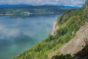 Bluff beside ocean, mountains beyond